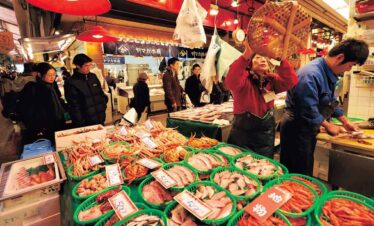 Vibrant seafood stall with fresh fish and shellfish at a lively night market.