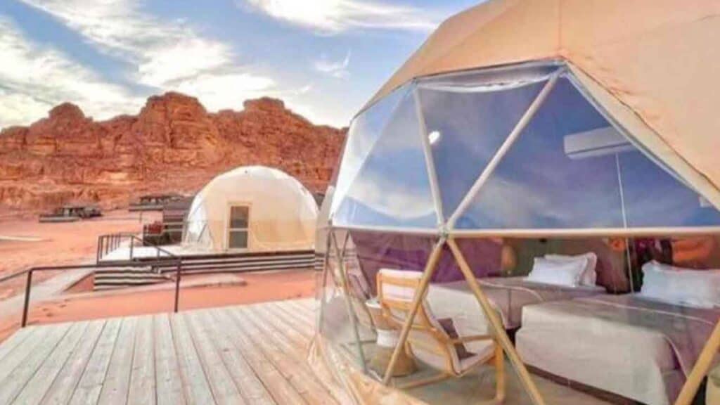Glamping tent with modern interior set against a stunning desert backdrop at Travel Buddies Holidays.