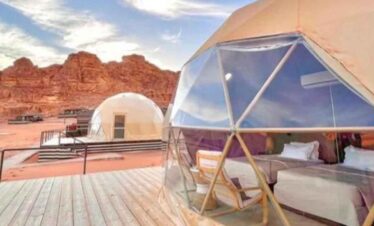 Glamping tent with modern interior set against a stunning desert backdrop at Travel Buddies Holidays.