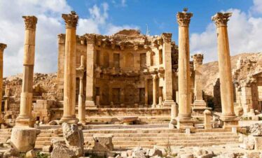 Roman theatre ruins in Jerash, Jordan, with tall columns and stone steps.