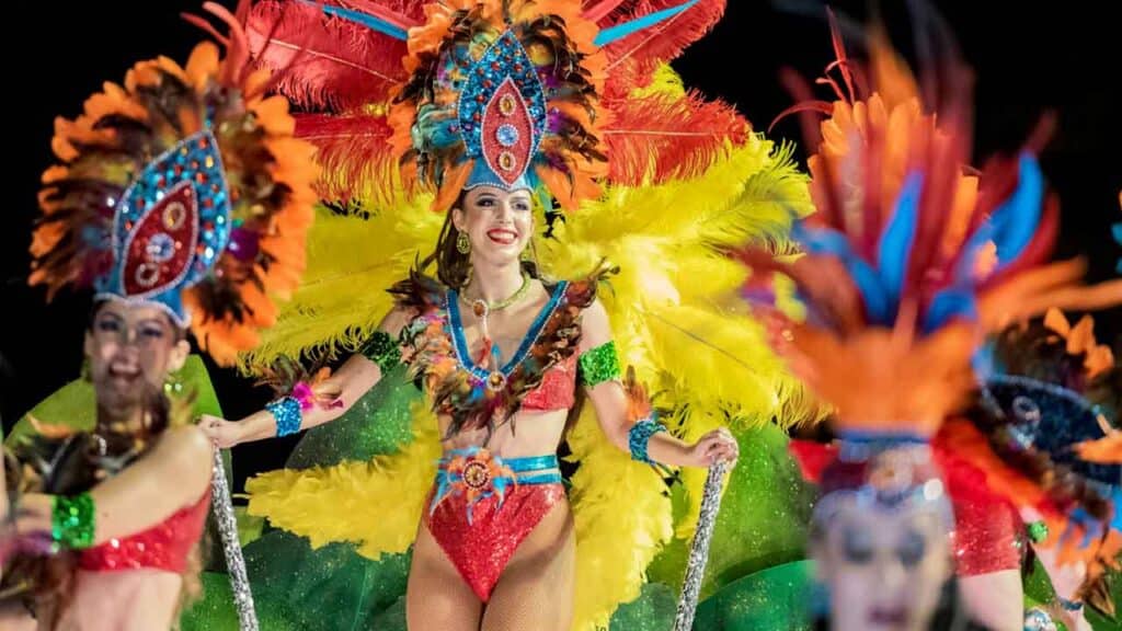 Vibrant carnival dancers wearing elaborate feathered costumes and headdresses.