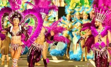 Colourful carnival dancers in elaborate costumes and feathers.