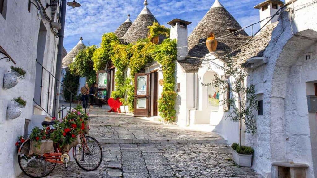 Picturesque white village with cone-shaped roofs and lush greenery, perfect for travel enthusiasts.