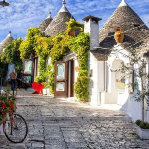 Picturesque white village with cone-shaped roofs and lush greenery, perfect for travel enthusiasts.