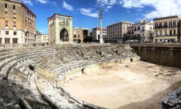 Ancient Roman amphitheatre ruins located in the heart of the city, showcasing historical architectur.
