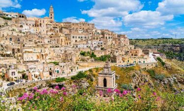 Colourful hillside town with historic buildings and panoramic views of the landscape.