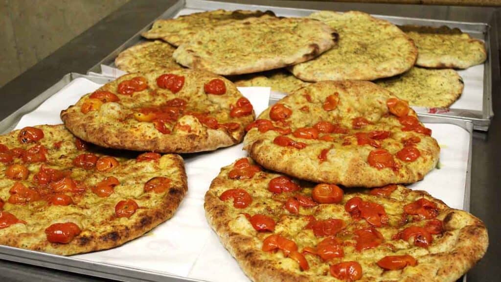 Style flatbreads topped with cherry tomatoes and herbs, freshly baked and crispy.