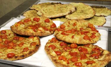 Style flatbreads topped with cherry tomatoes and herbs, freshly baked and crispy.