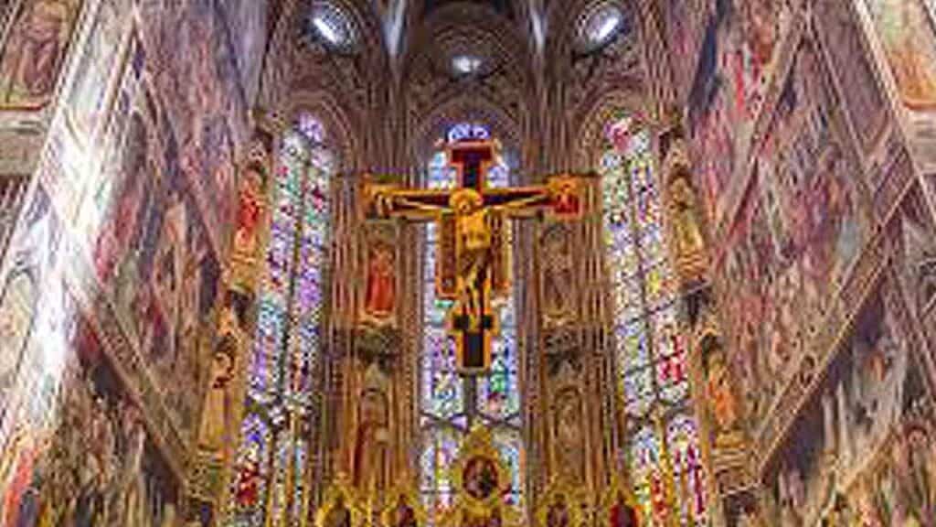 Stunning Gothic cathedral interior with colourful stained glass windows and intricate architecture.