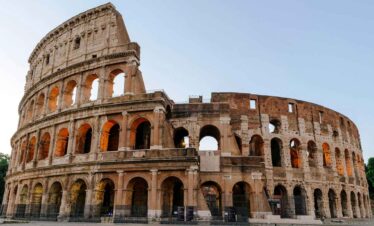 Ancient Roman Colosseum with warm sunset lighting and clear sky.