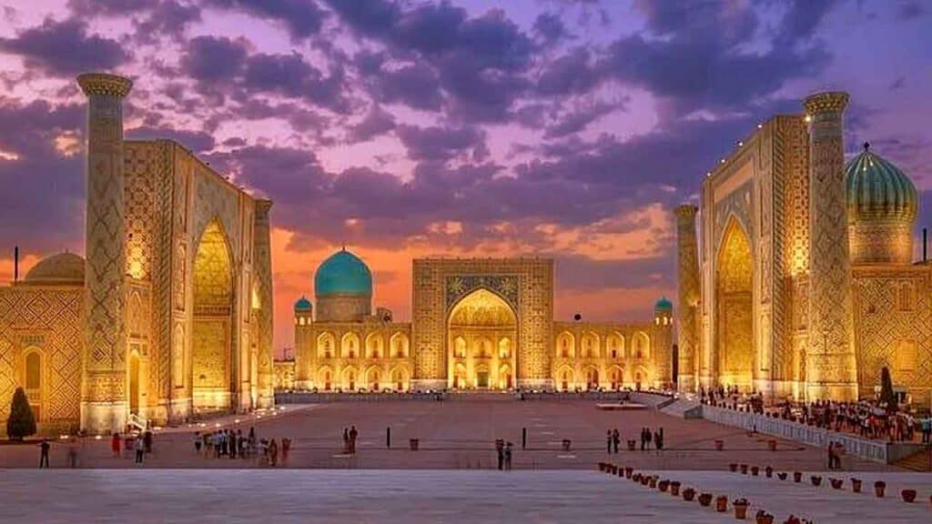 Blue Mosque with illuminated minarets during sunset.