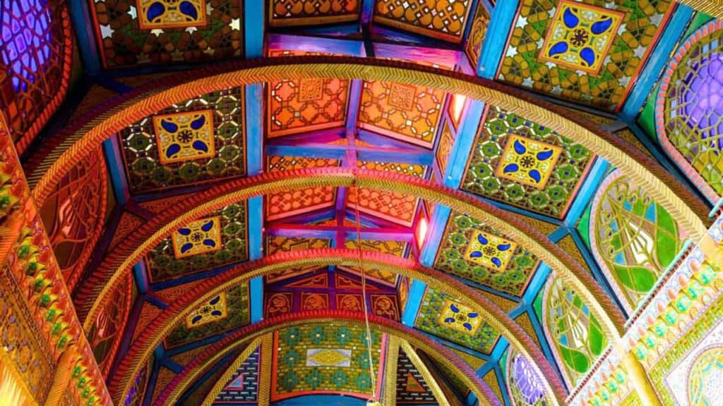 Vibrant, intricate mosque ceiling with detailed patterns and bright colours.