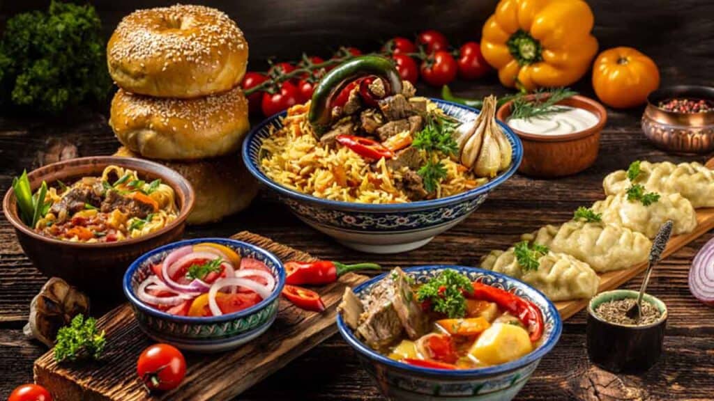 Assorted traditional dishes with vegetables, rice, and meat on a rustic table.
