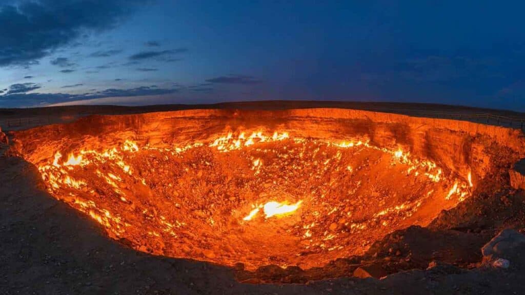 Volcanic crater glowing with lava during sunset, showcasing natural geothermal activity.