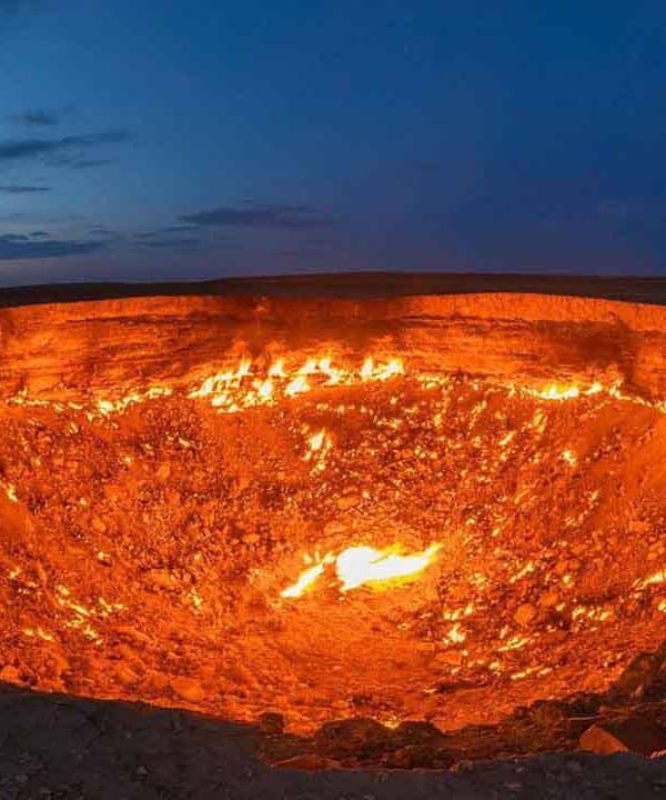 Volcanic crater glowing with lava during sunset, showcasing natural geothermal activity.