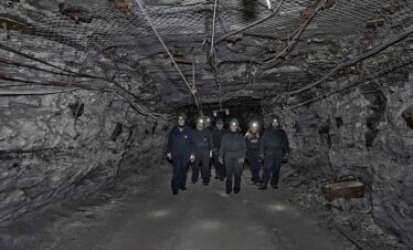 Group of people exploring an underground mine tunnel.