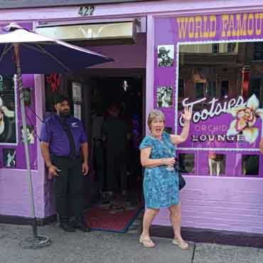 Woman and staff outside Orchid Lounge, a popular travel destination.