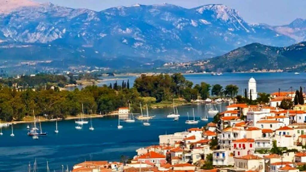 Beautiful coastal town with boats and mountains in the background.