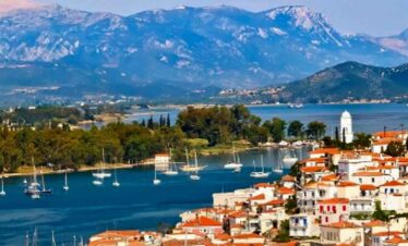 Beautiful coastal town with boats and mountains in the background.