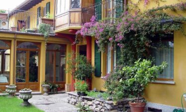 Colourful villa with lush greenery and blooming flowers, perfect for a relaxing holiday stay.