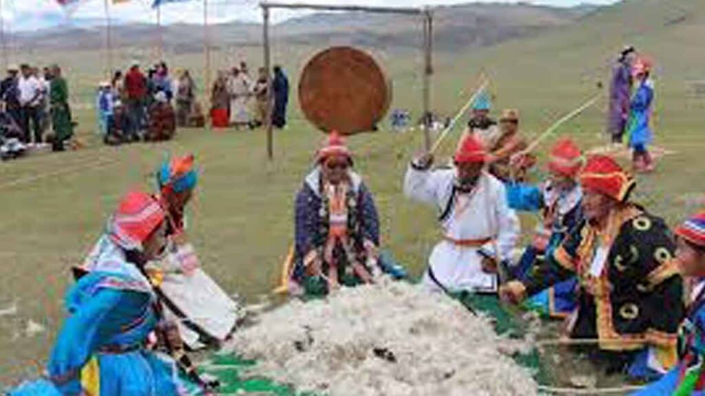 Traditional Mongolian nomadic gathering with people in colourful attire.
