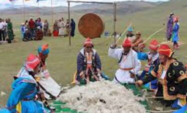 Traditional Mongolian nomadic gathering with people in colourful attire.