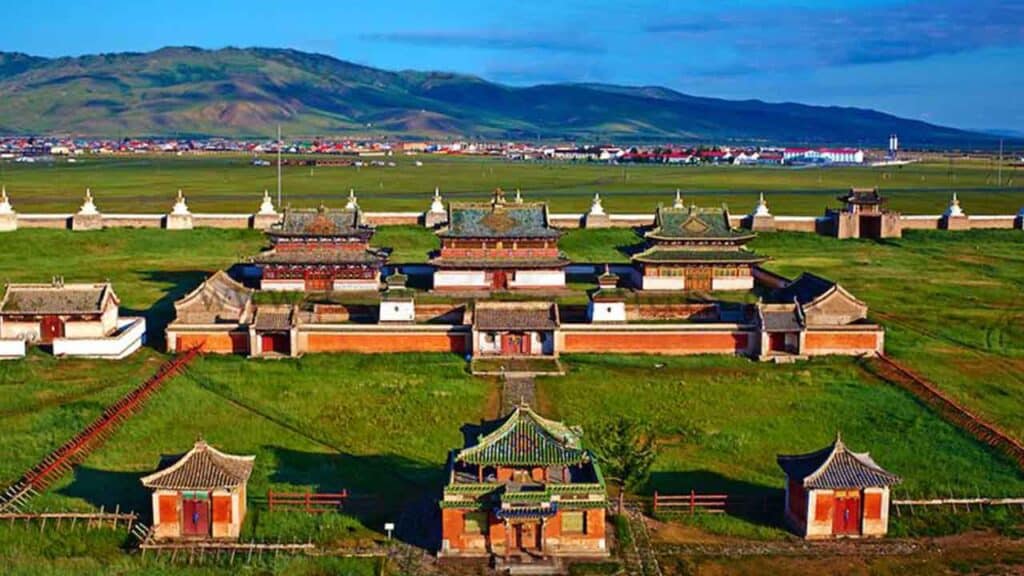 Ancient Mongolian monastery complex with traditional architecture and lush green surroundings.
