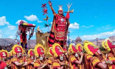 Vibrant festival parade featuring traditional costumes and a regal figure on a decorated float.