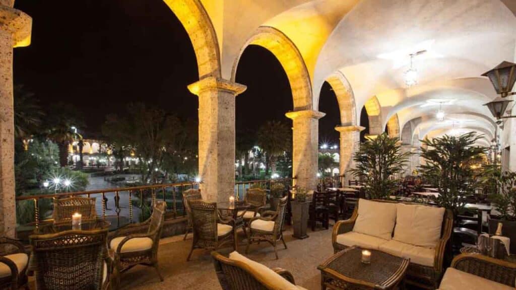 Night view of a cosy terrace with arches and seating at Travel Buddies Holidays.