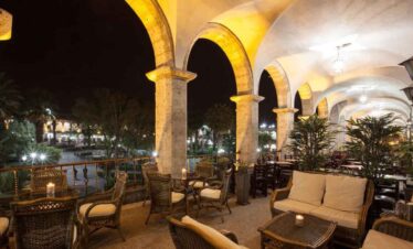 Night view of a cosy terrace with arches and seating at Travel Buddies Holidays.