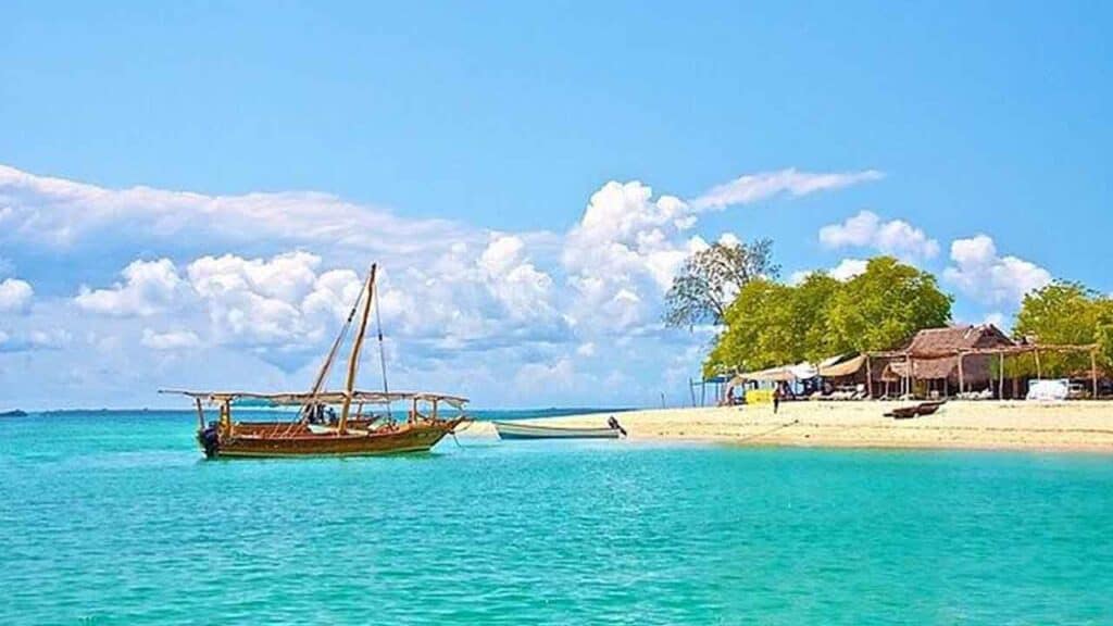 Scenic tropical beach with a traditional wooden boat and clear turquoise waters.
