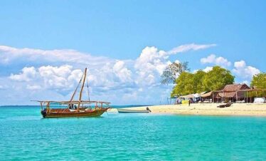 Scenic tropical beach with a traditional wooden boat and clear turquoise waters.