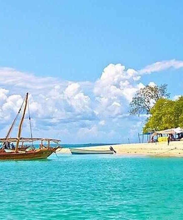 Scenic tropical beach with a traditional wooden boat and clear turquoise waters.