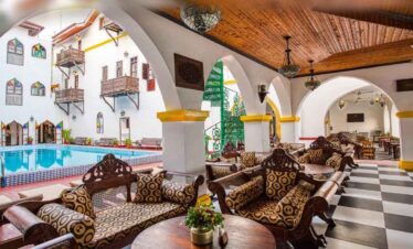 Traditional Moroccan riad with pool, arches, and intricate decor for a relaxing holiday experience.