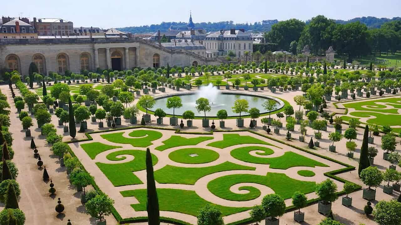 Beautiful view of the meticulously landscaped gardens at Palace of Versailles, featuring geometric p.